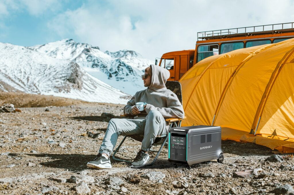 a man sitting in a chair next to a tent